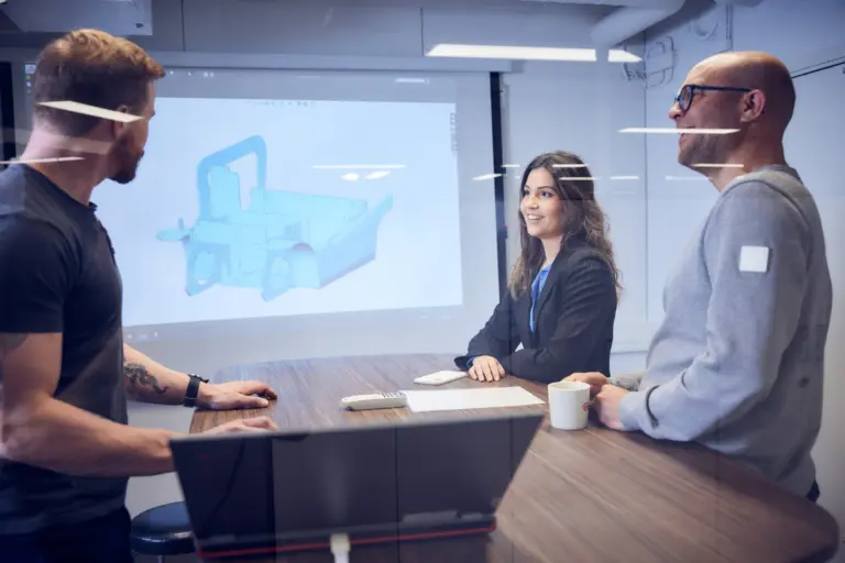 Möte i konferensrum där en CAD-modell av en trucksmast presenteras på storskärm