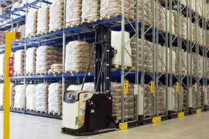 Autonom truck vid rörliga pallställ (mobile racking) i ett lager med säckgods på pallar