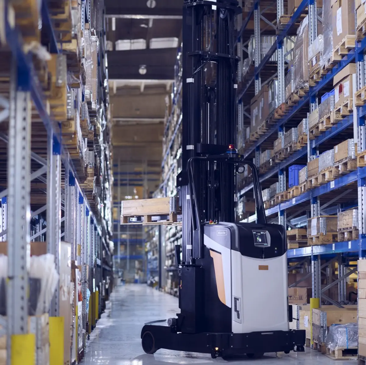 Autonom truck (AGV) i en lagergång mellan höga pallställ fyllda med gods