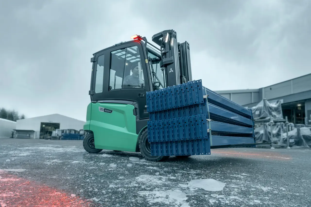 Mitsubishi Edia 35 motviktstruck transporterar hyllprofiler utomhus på isig asfalt – Logisnext