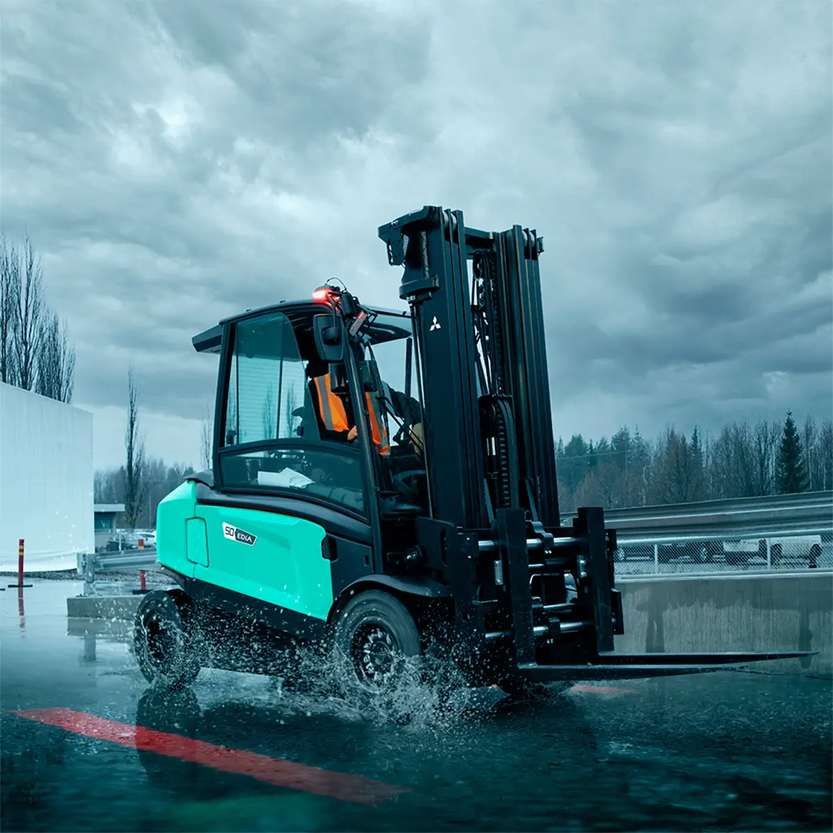 Eldriven motviktstruck ur Logisnext EDiA-serien som kör utomhus genom vattenpölar i regnväder, med röd säkerhetsbelysning på marken